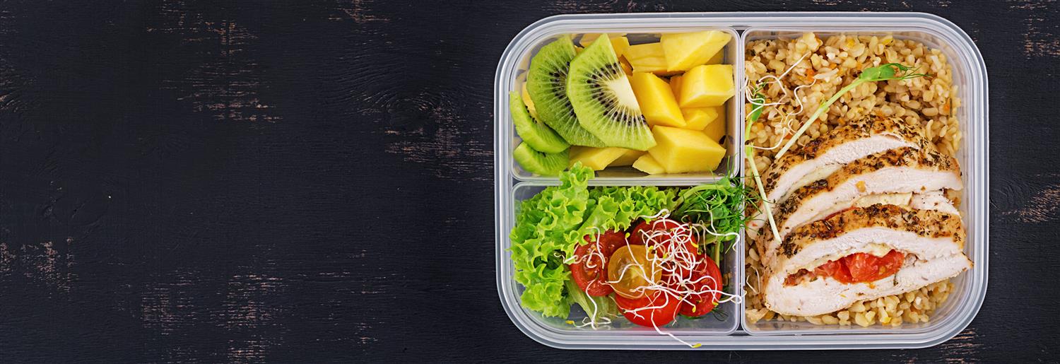 school lunch with rice, chicken, kiwi, pineapple and salad